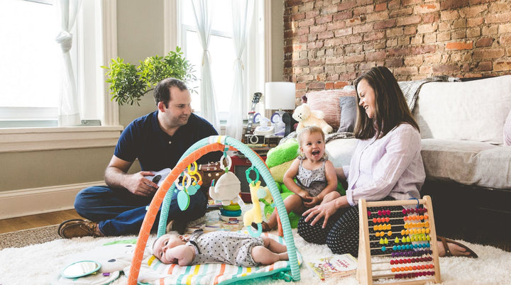 Mom and dad sitting on bed with new baby