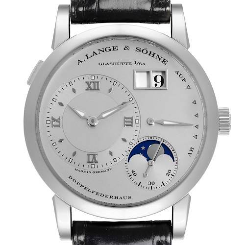 The Lange 1 by A. Lange & Söhne is shown from the front, displaying the dial, Roman numerals, moon phase, and date window.