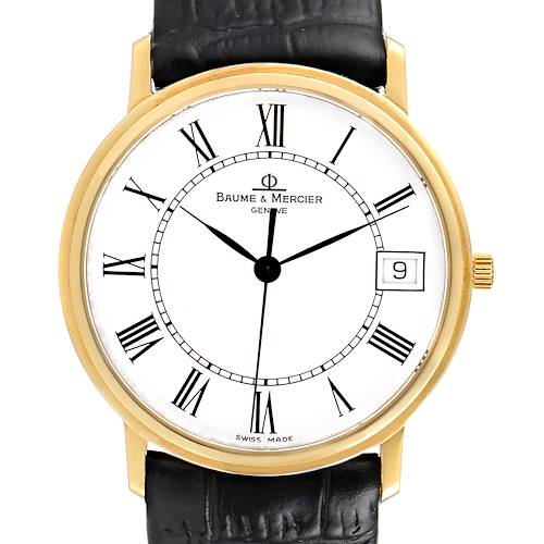 The image shows a front view of a Baume & Mercier Classima MV045093 Men's Yellow Gold White Dial MV045093 Men's Yellow Gold White Dial watch with a gold case, black leather strap, and white dial.