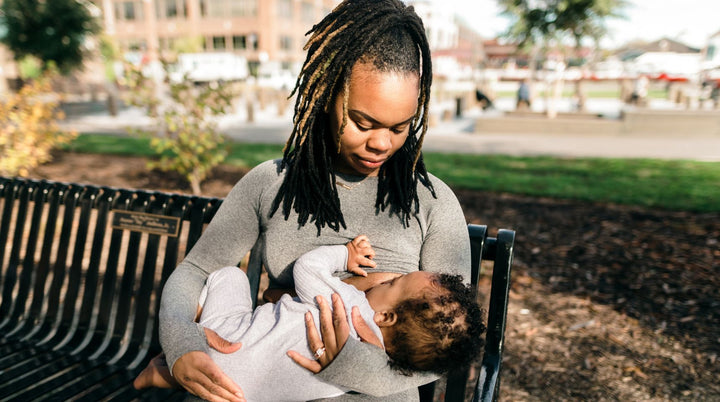 Mom sitting in chair breastfeeding baby