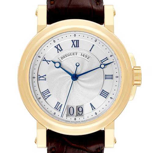 This Breguet Marine 5817BA/12/9V8 Men's Yellow Gold Silver Dial 5817BA/12/9V8 Men's Yellow Gold Silver Dial watch is pictured from the front, displaying its face, Roman numerals, blue hands, date window, and gold casing.