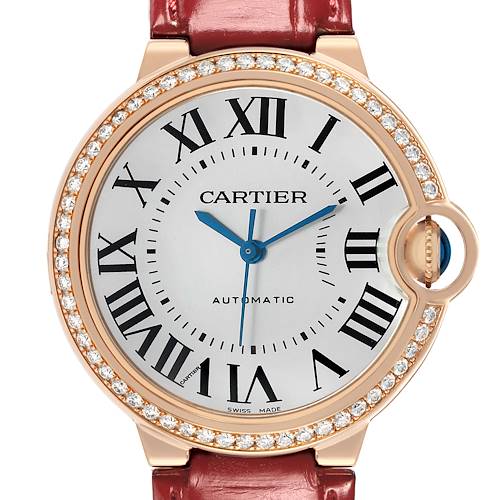 The image shows a frontal view of the Cartier Ballon Bleu WJBB0034 Women's Rose Gold Silver Dial watch, highlighting its Roman numerals, blue hands, and diamond-set bezel.
