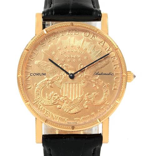 The image shows a front view of the Corum Coin Watch Men's Yellow Gold Black Dial Men's Yellow Gold Black Dial model, featuring a gold coin face with black hands and a black leather strap.