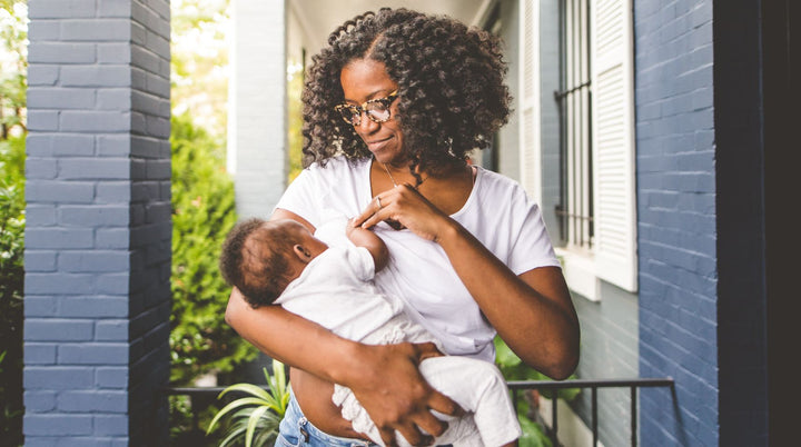 Mom breastfeeding baby on the bed